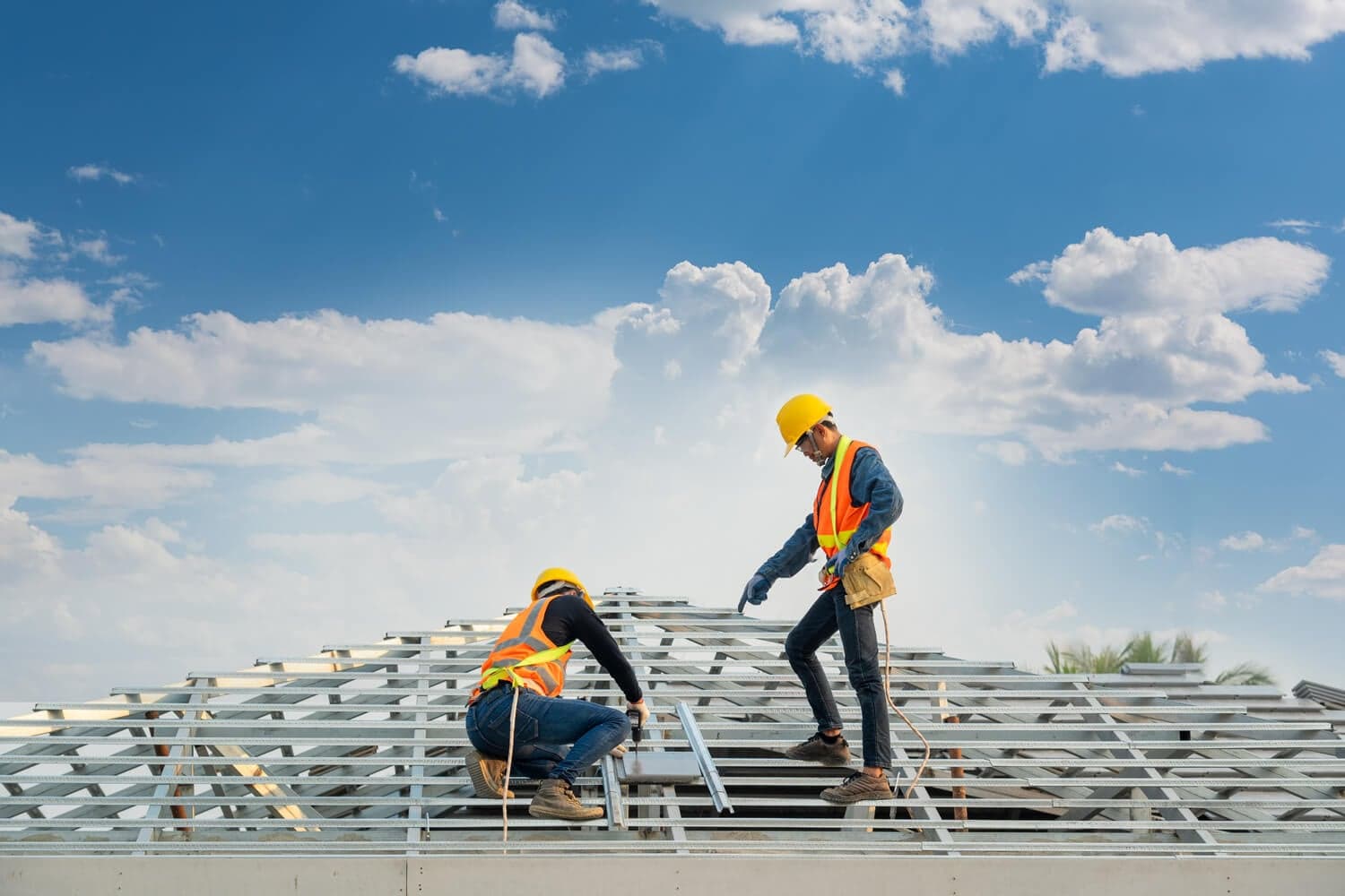 Two men in safety vests working on a roof, representing Titan Exteriors' commitment to safe construction practices. Two men in safety vests working on a roof, representing Titan Exteriors' commitment to safe construction practices.